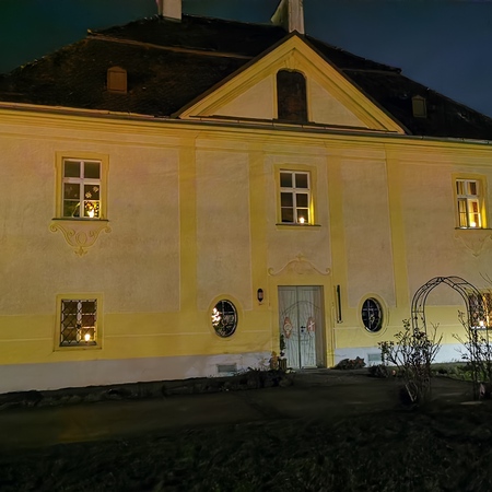 Die erleuchtete Front des Pfarrhofs 